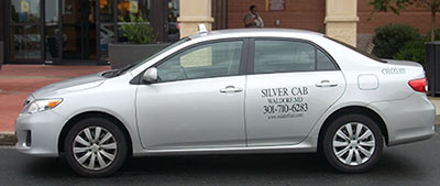 two silver cabs in front of shopping mall 